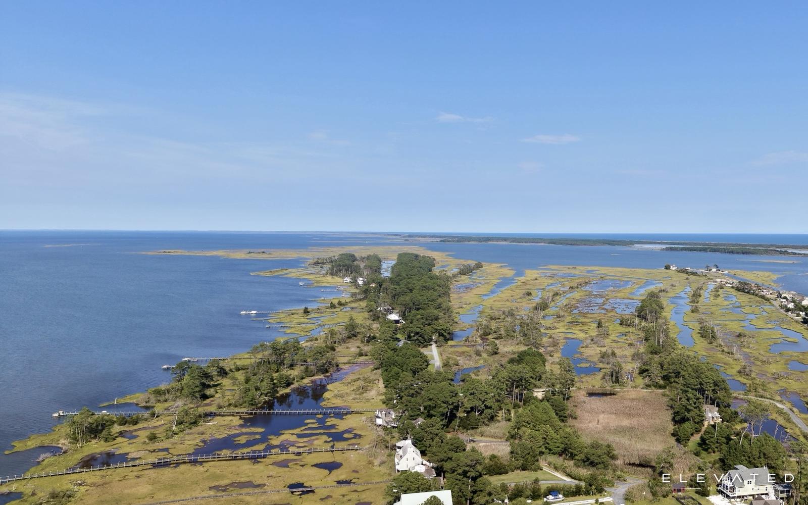 Aerial view of a barrier marsh, waterfront homes, and the bay